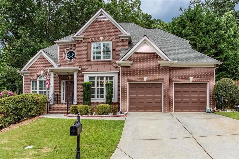 Traditional home with concrete driveway, brick siding, a front lawn, and a shingled roof