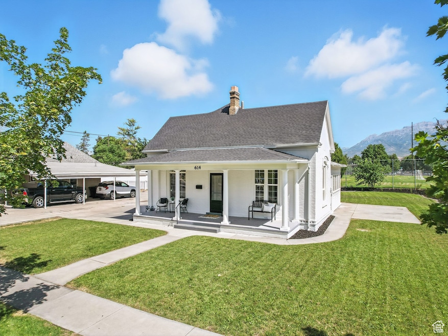 Back of property featuring a shingled roof, covered porch, and a chimney