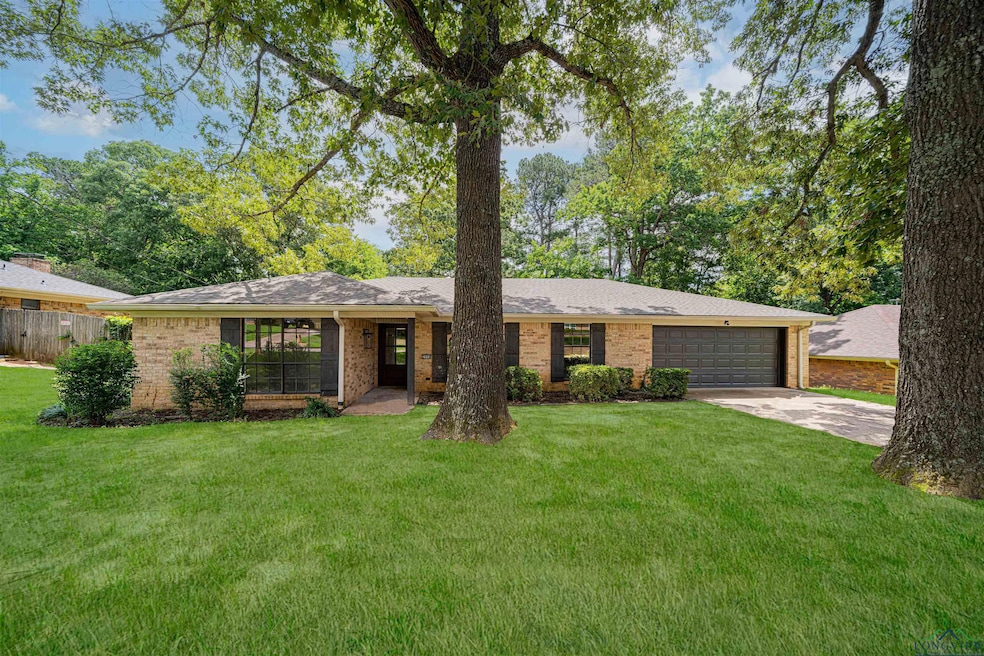 Ranch-style house featuring a garage, concrete driveway, brick siding, and roof with shingles