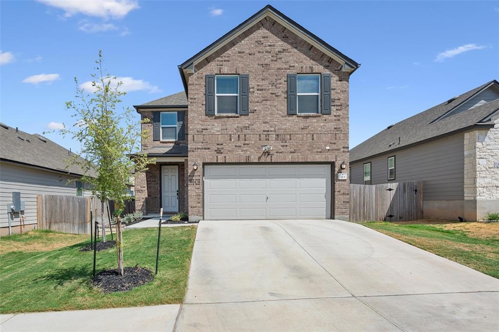 Traditional-style home with brick siding, driveway, and an attached garage