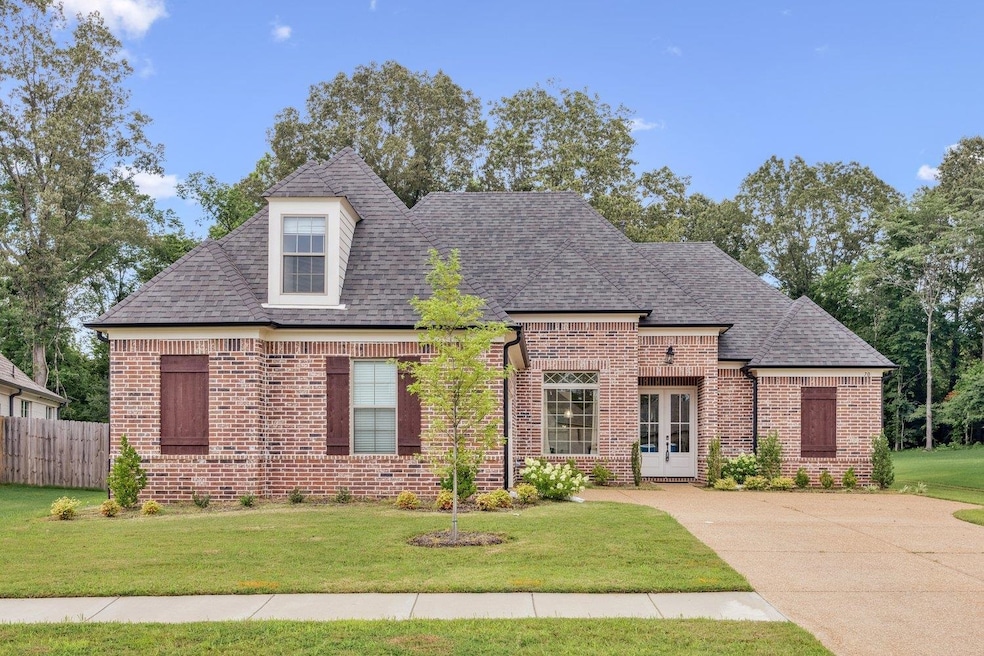 View of front of property with brick siding, french doors, and a shingled roof