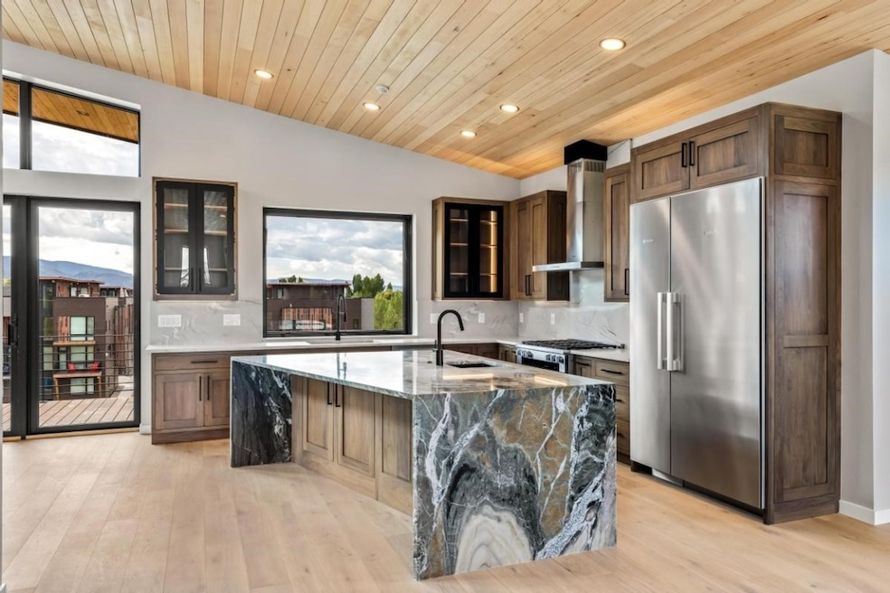 Kitchen featuring lofted ceiling, wall chimney exh