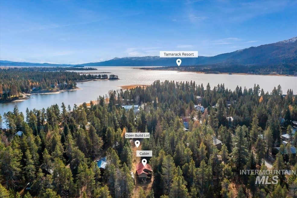 Aerial view of property's location with a heavily wooded area and a water and mountain view