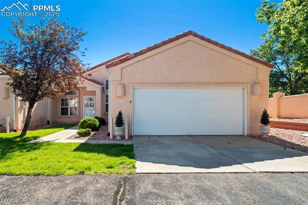 View of front facade with stucco siding, driveway, a garage, and a front lawn