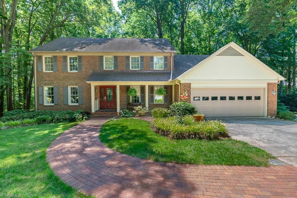 Traditional brick home, surrounded by mature landscaping.