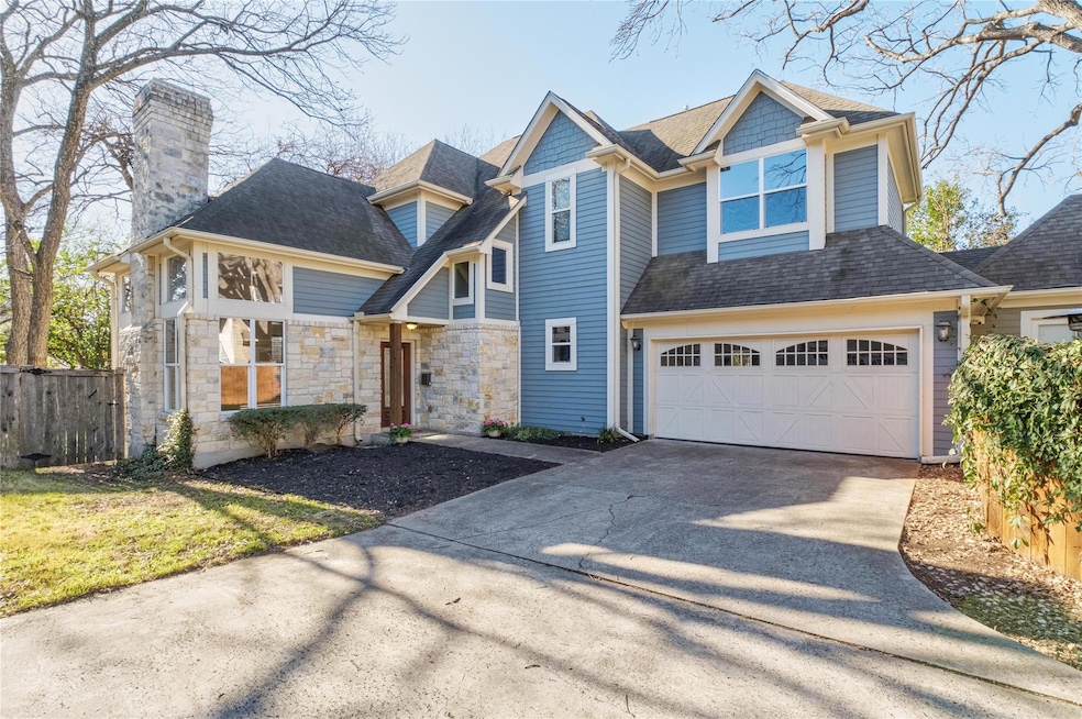 View of front facade with driveway, fence, roof w