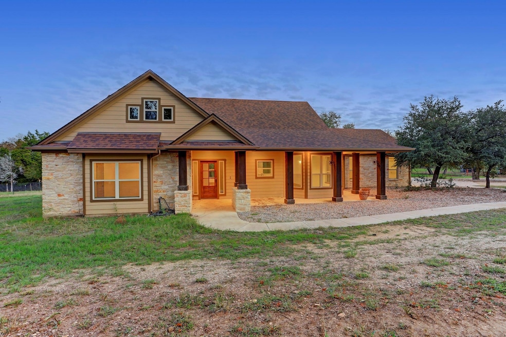 View of front of house with stone siding, roof wi