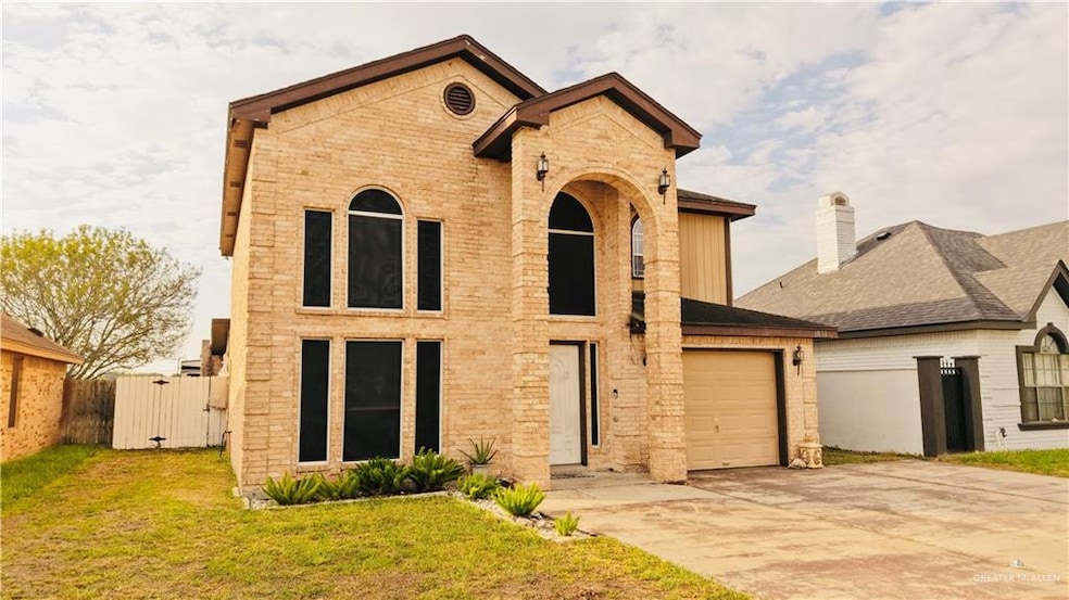 View of front of property with concrete driveway, a gate, a garage, and brick siding