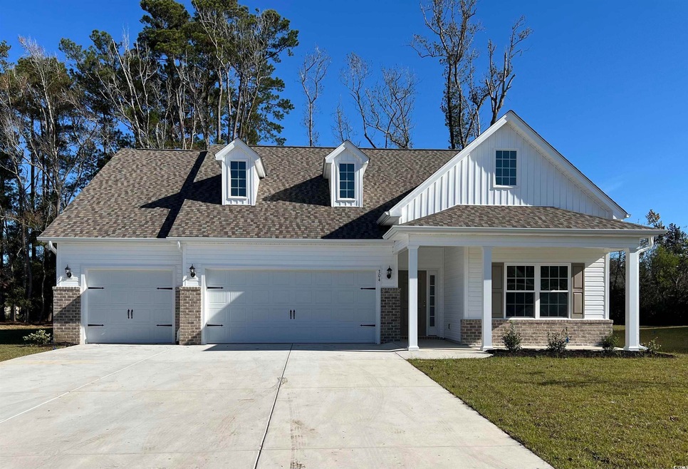 View of front of house with covered porch, a garag