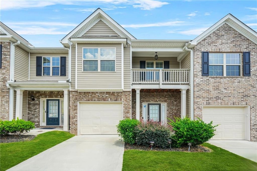 Craftsman inspired home featuring a balcony, a garage, and driveway