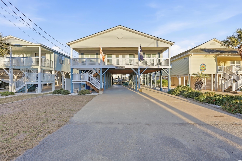 View of building exterior with a carport, stairs, and concrete driveway