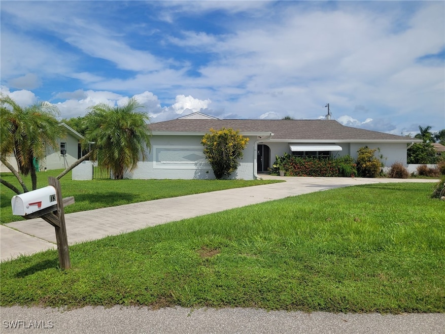 Ranch-style home with a front yard and a garage