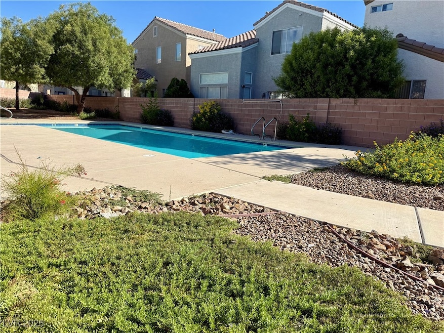 Community pool with a fenced backyard and a patio area