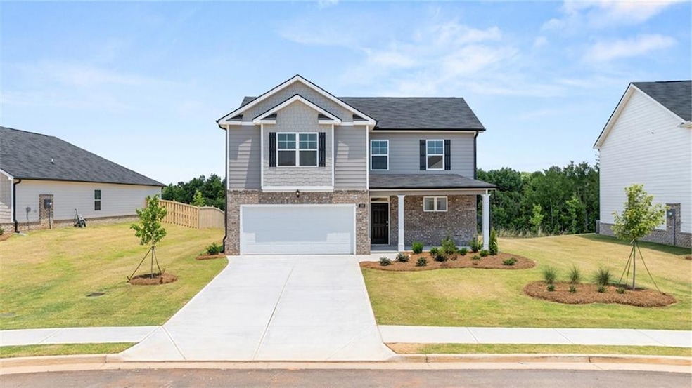 View of front facade featuring a garage and a front yard