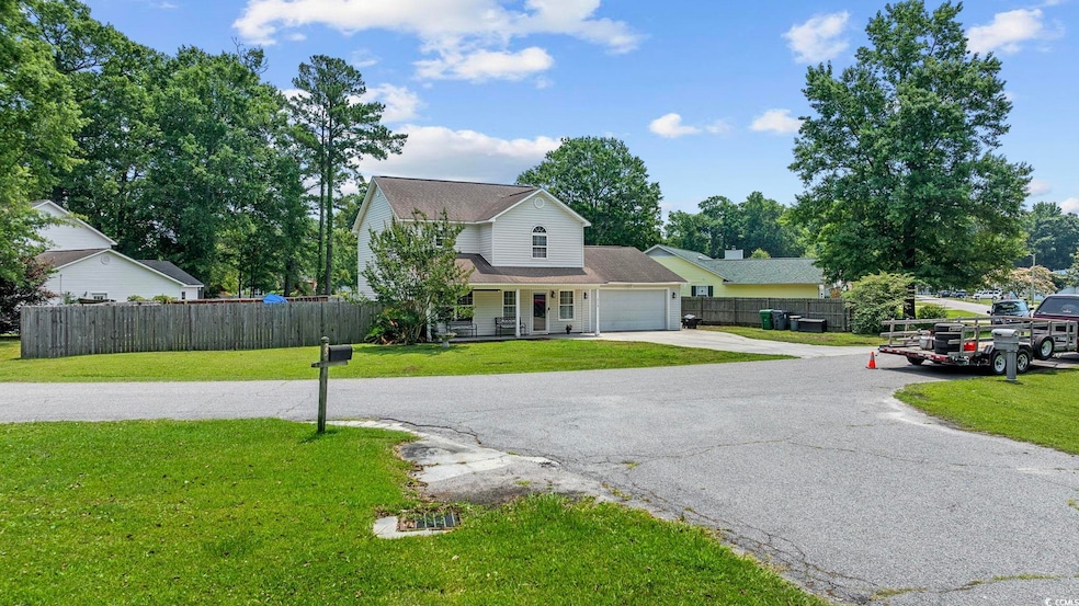 View of front of home with a garage, concrete driveway, and a porch