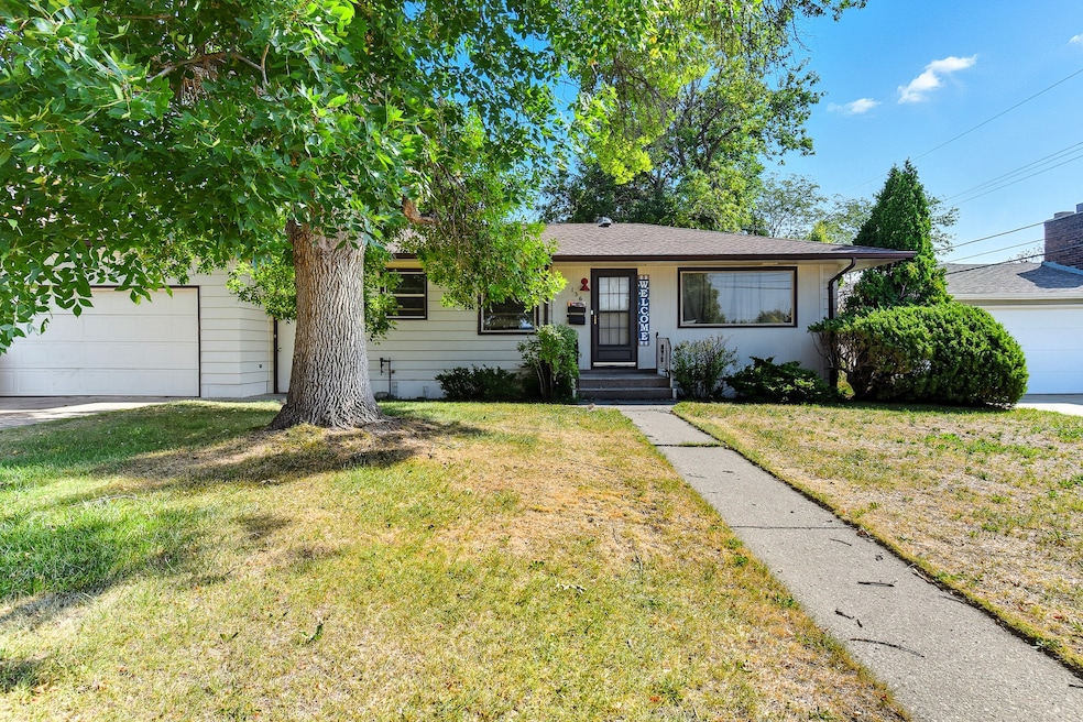 View of front facade featuring a garage, a front yard, and roof with shingles