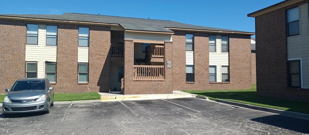 View of building exterior with uncovered parking