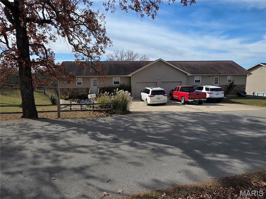 Ranch-style home featuring driveway, a garage, and a shingled roof