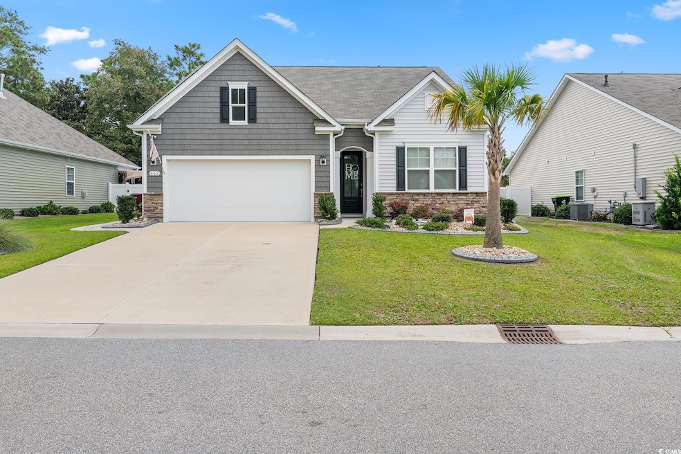 Craftsman house featuring driveway, a garage, stone siding, and central AC