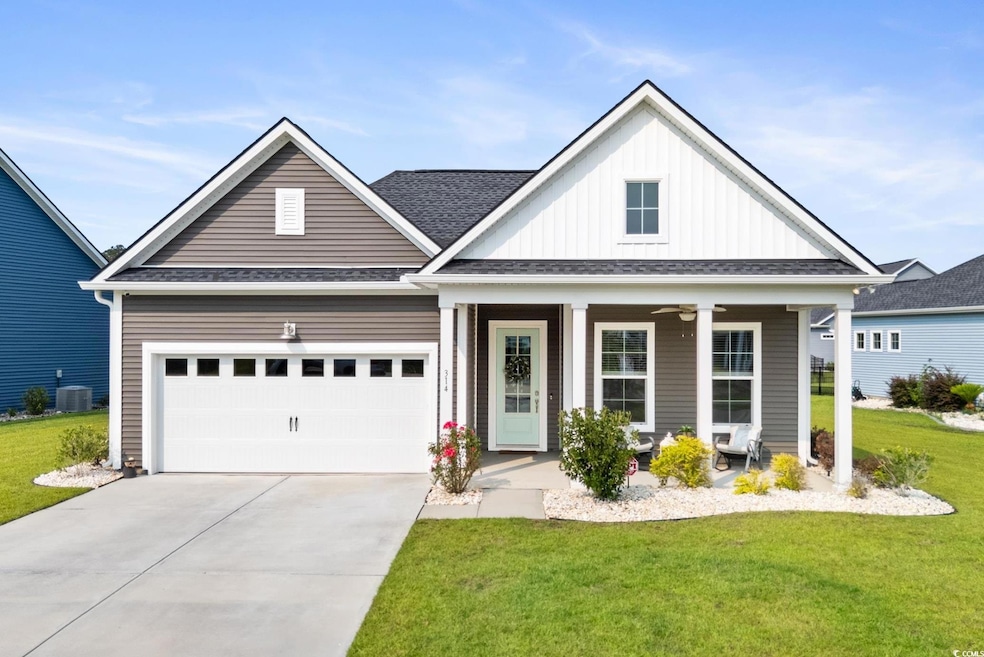 View- front of the home featuring a covered porch, 2 car garage and detailed landscaping.