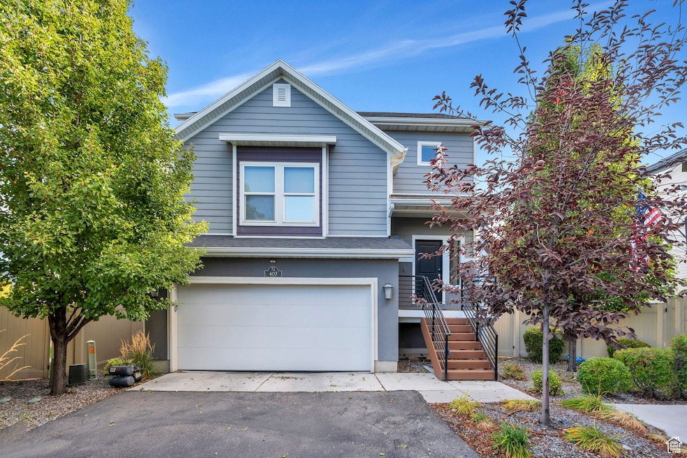 View of front of house featuring an attached garage, driveway, and a shingled roof