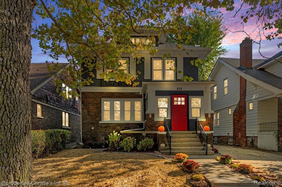 American foursquare style home featuring brick siding