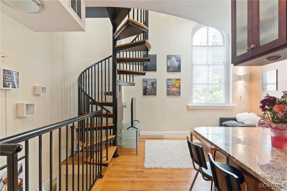Stairway with wood finished floors and baseboards