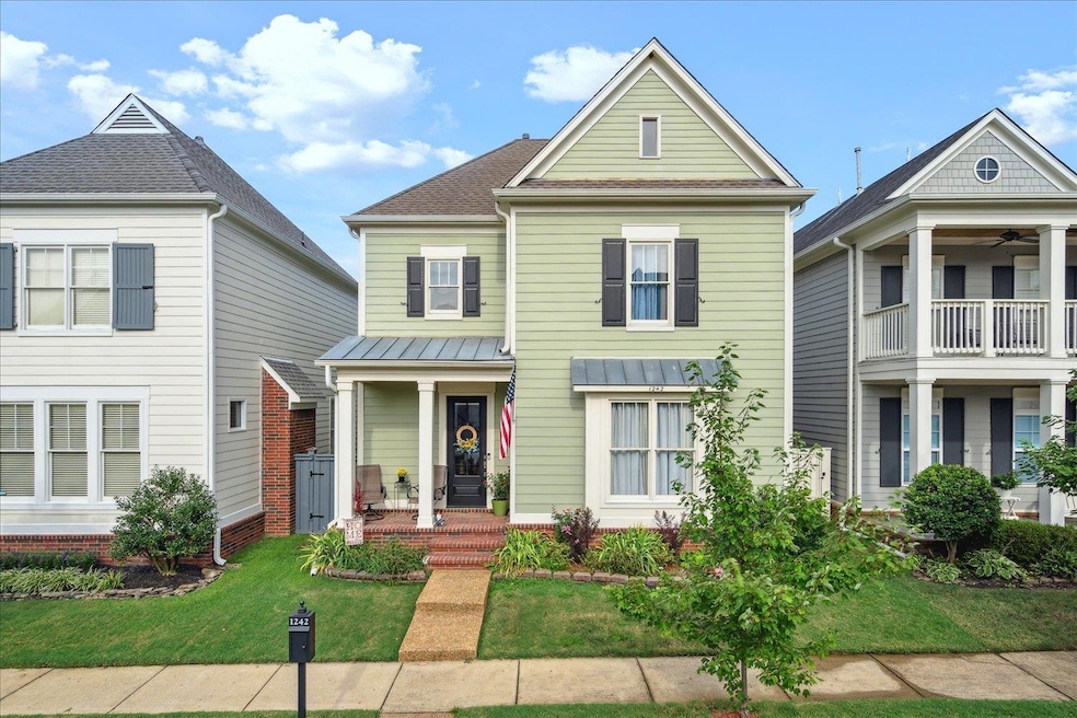 View of front of house with ceiling fan, a balcony, and a front yard
