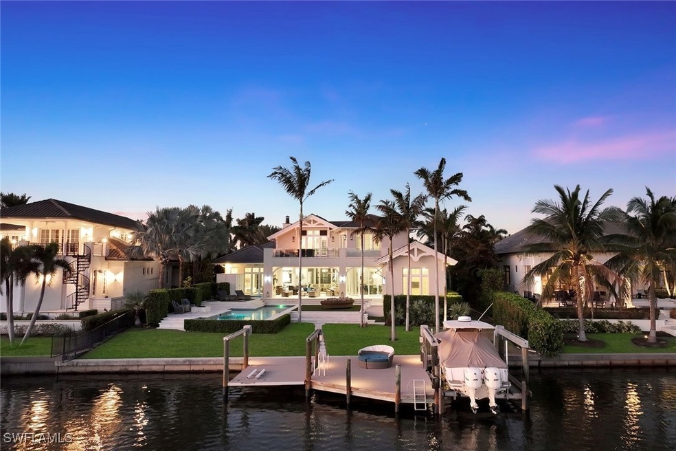 Dock area featuring a water view, a patio, boat lift, a yard, and an outdoor pool