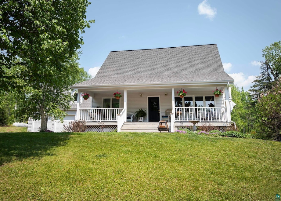 View of front of house featuring covered porch, a front yard, and roof with shingles
