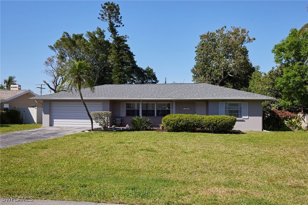 Ranch-style home with fence, a front yard, stucco