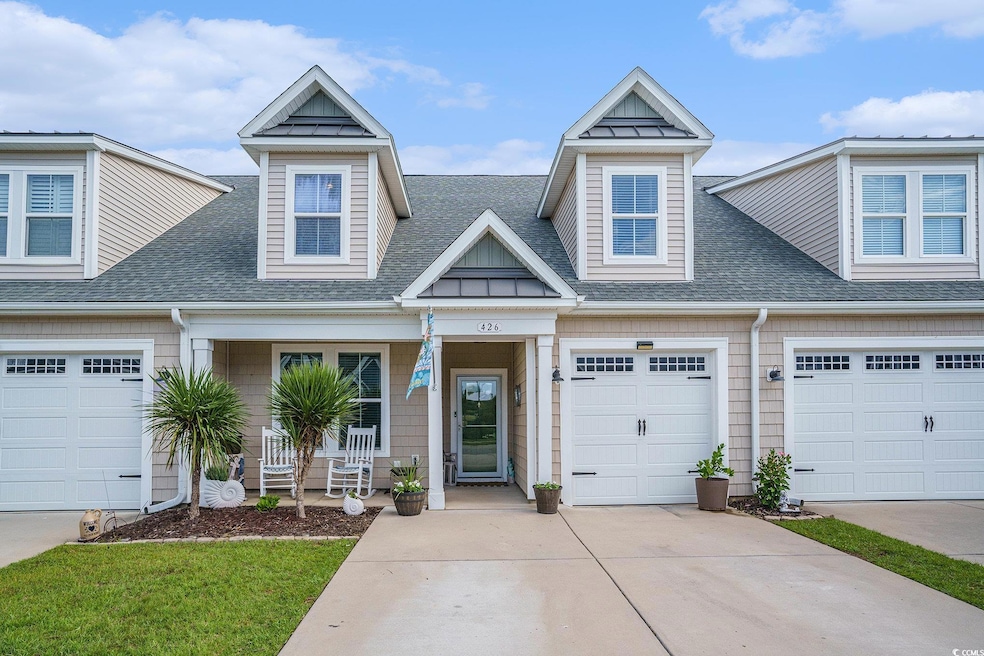 View of front of home featuring a porch, a shingled roof, a garage, and driveway