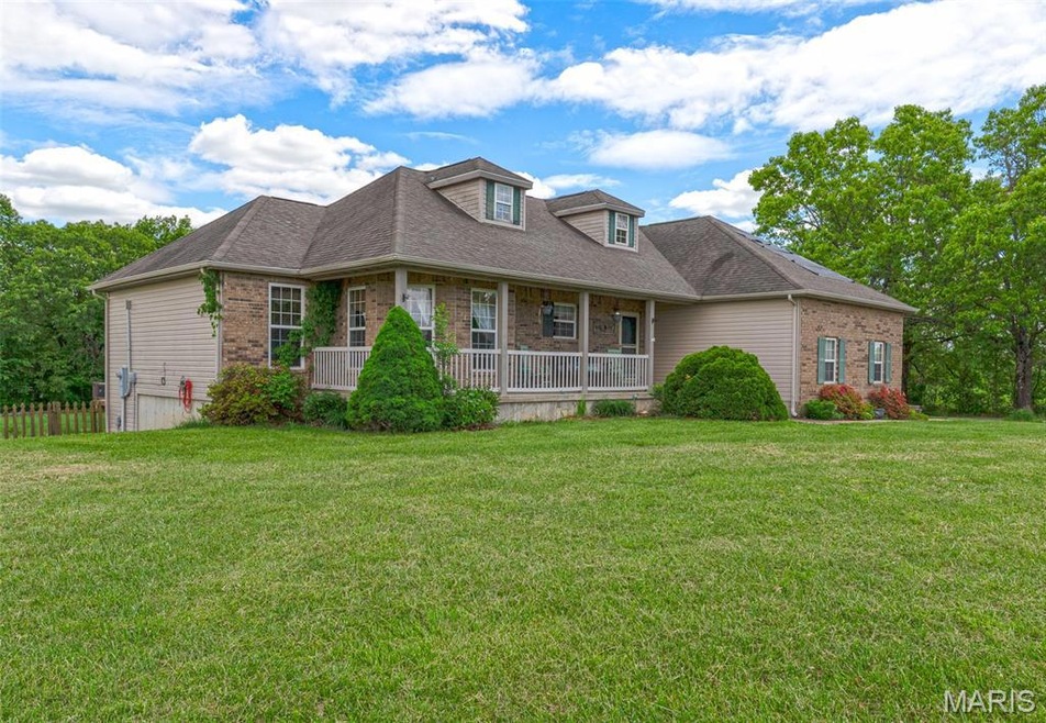 View of front of house featuring brick siding and covered porch