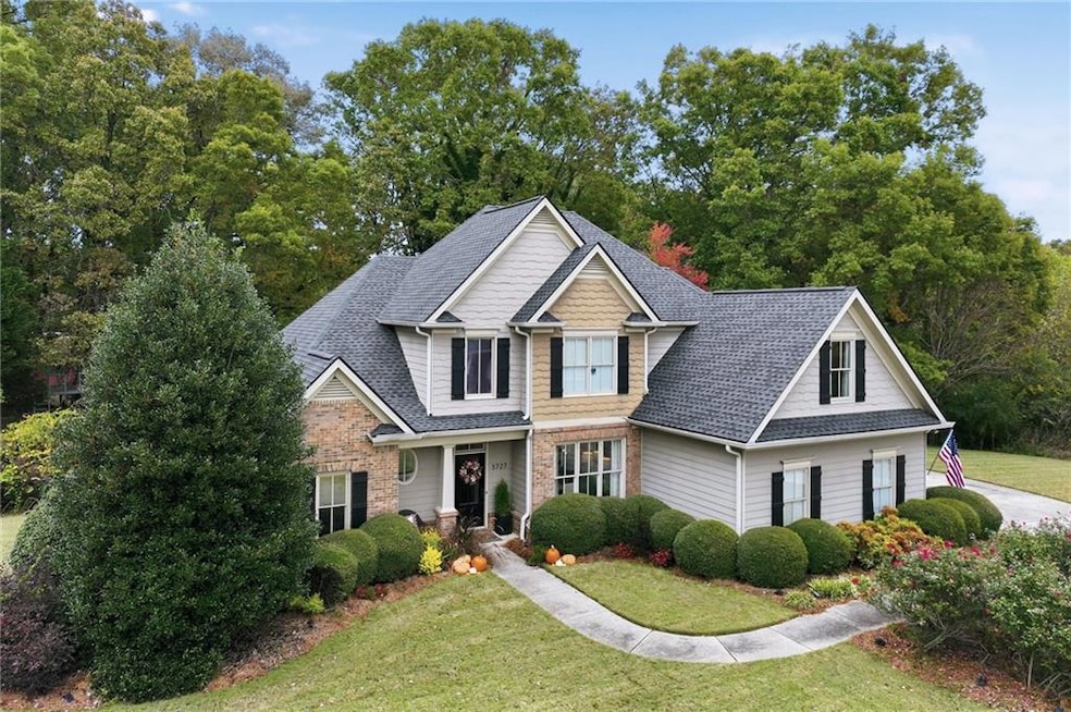 View of front facade with a front yard and a shingled roof