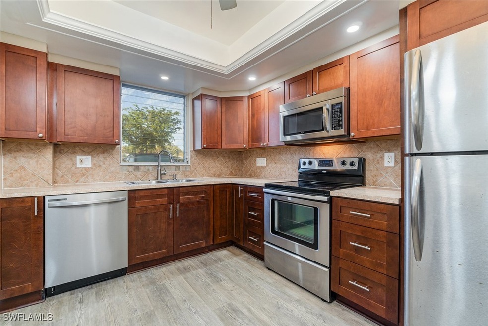 Kitchen with sink, backsplash, a tray ceiling, sta