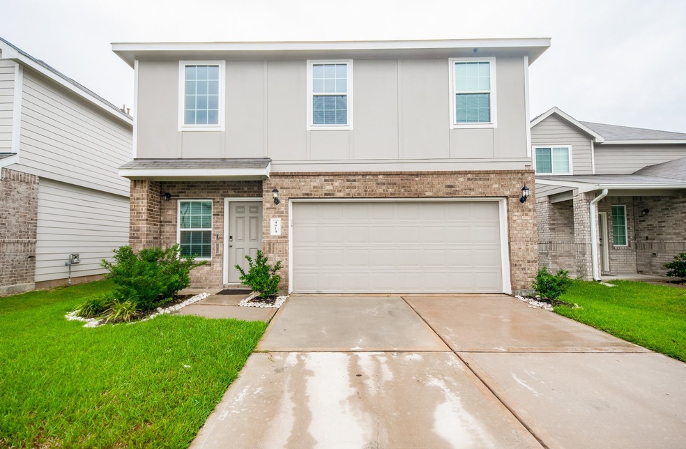 This is a modern two-story home with a mix of brick and siding exterior, featuring a two-car garage and a neatly landscaped entryway.