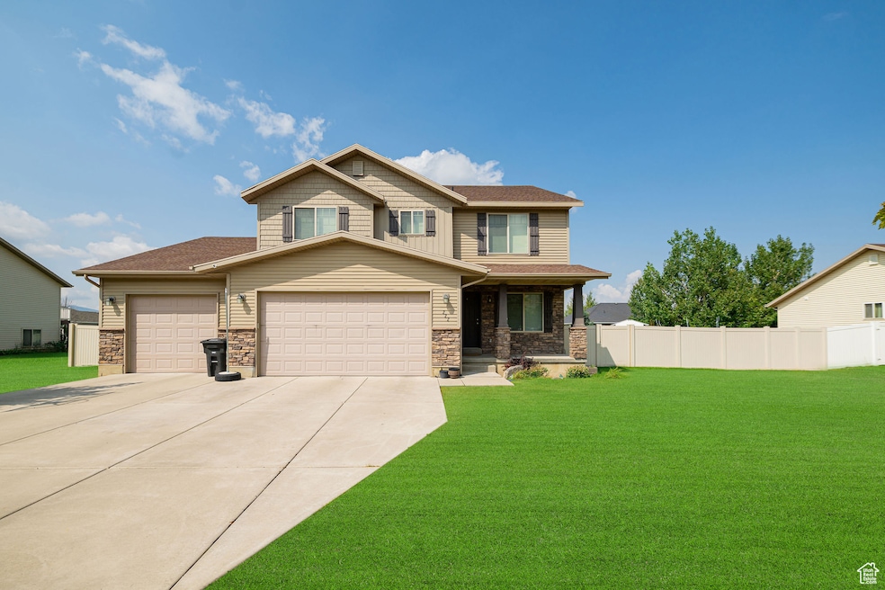 Craftsman-style home featuring covered porch, concrete driveway, a garage, and stone siding