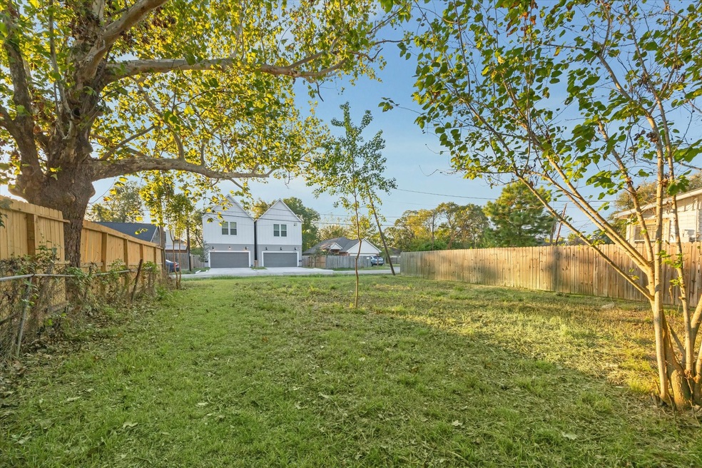 This photo showcases a spacious lot with mature tr