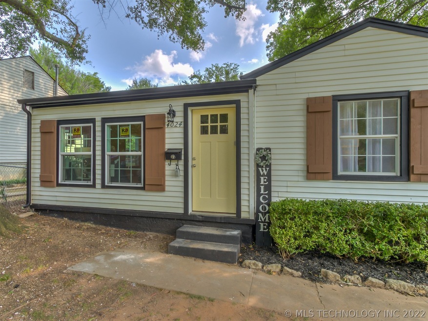 Welcoming front door with pine shutters for charm