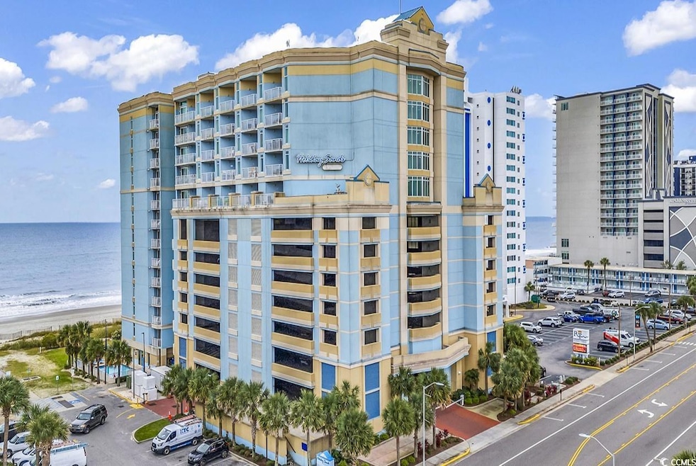 View of apartment building / complex with view of water and beach