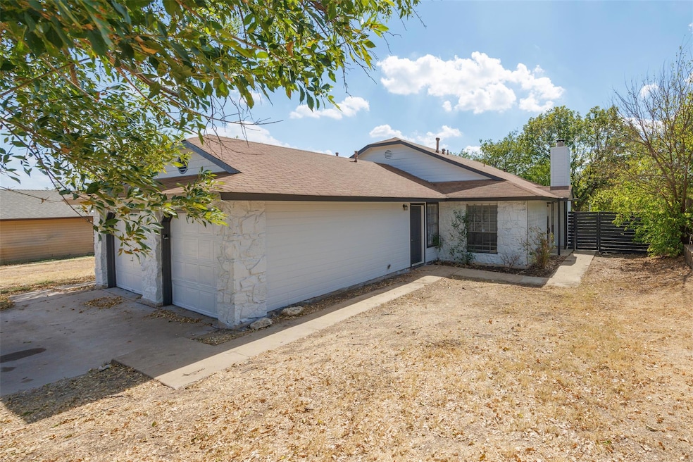 View of front facade with a chimney, a shingled roof, and stone siding