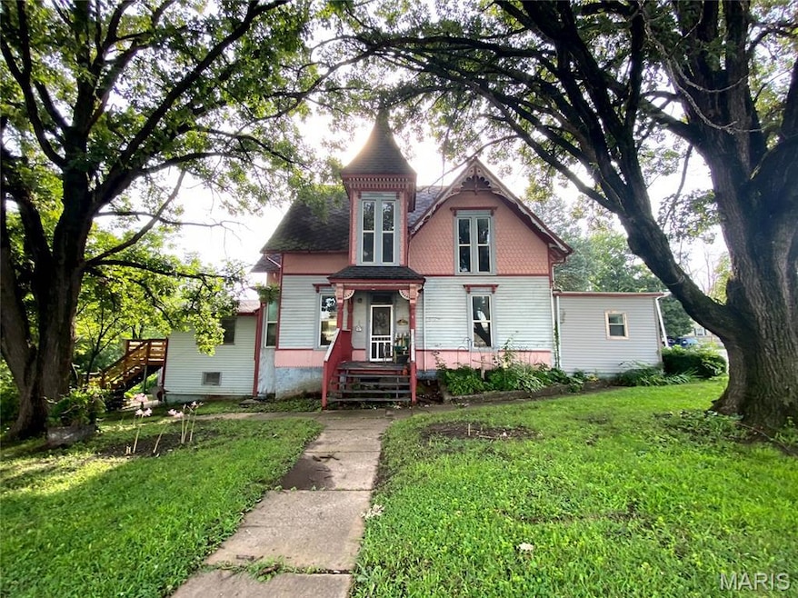 Victorian house featuring a front yard and stairway