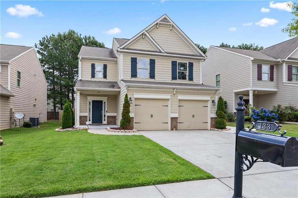View of front of house featuring driveway, an attached garage, a front lawn, and brick siding
