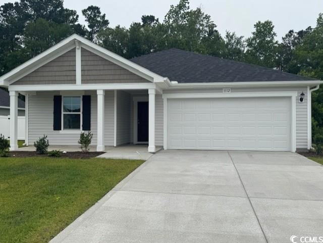 Ranch-style home featuring driveway, covered porch, a front lawn, and a garage