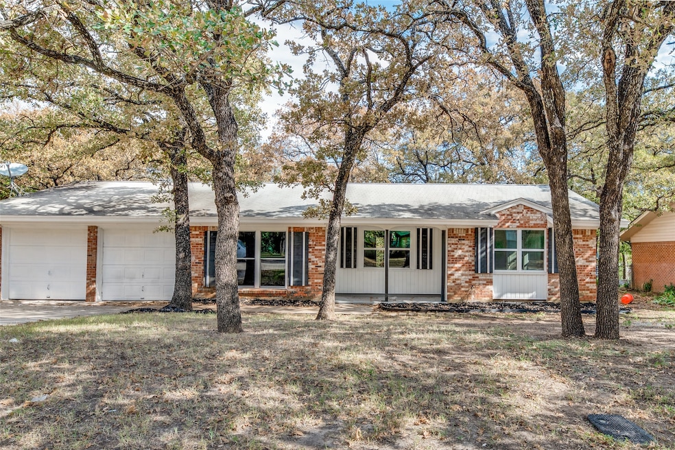 Single story home featuring brick siding, a garage, and driveway