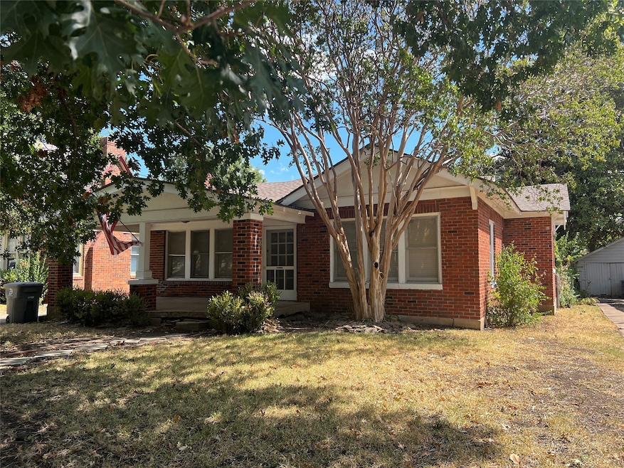 Single story home with brick siding and a front yard