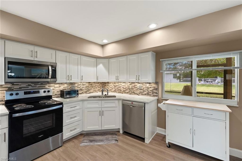 A versatile mobile island provides extra counter space and storage, enhancing the kitchen’s practicality while maintaining its open and airy feel—perfect for both everyday living and entertaining.