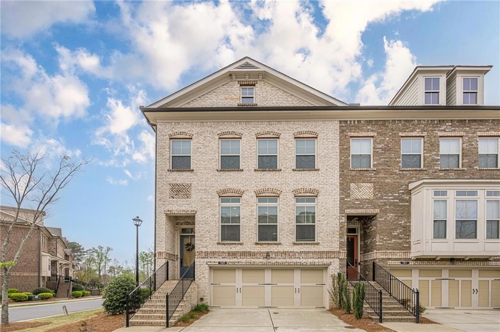 Multi unit property with brick siding, driveway, and an attached garage