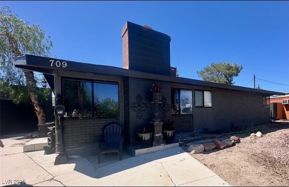 View of front of home with a chimney and a patio