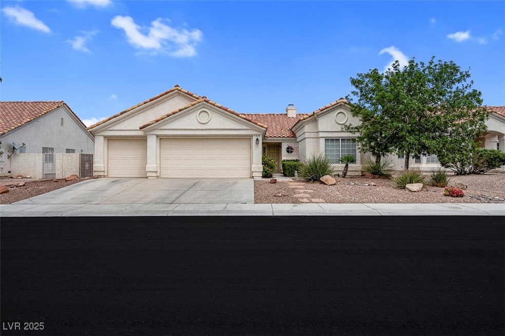 View of front of house featuring a tile roof, a ga